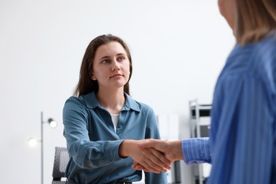 Photo of Cooperation and teamwork. Women shaking hands in office