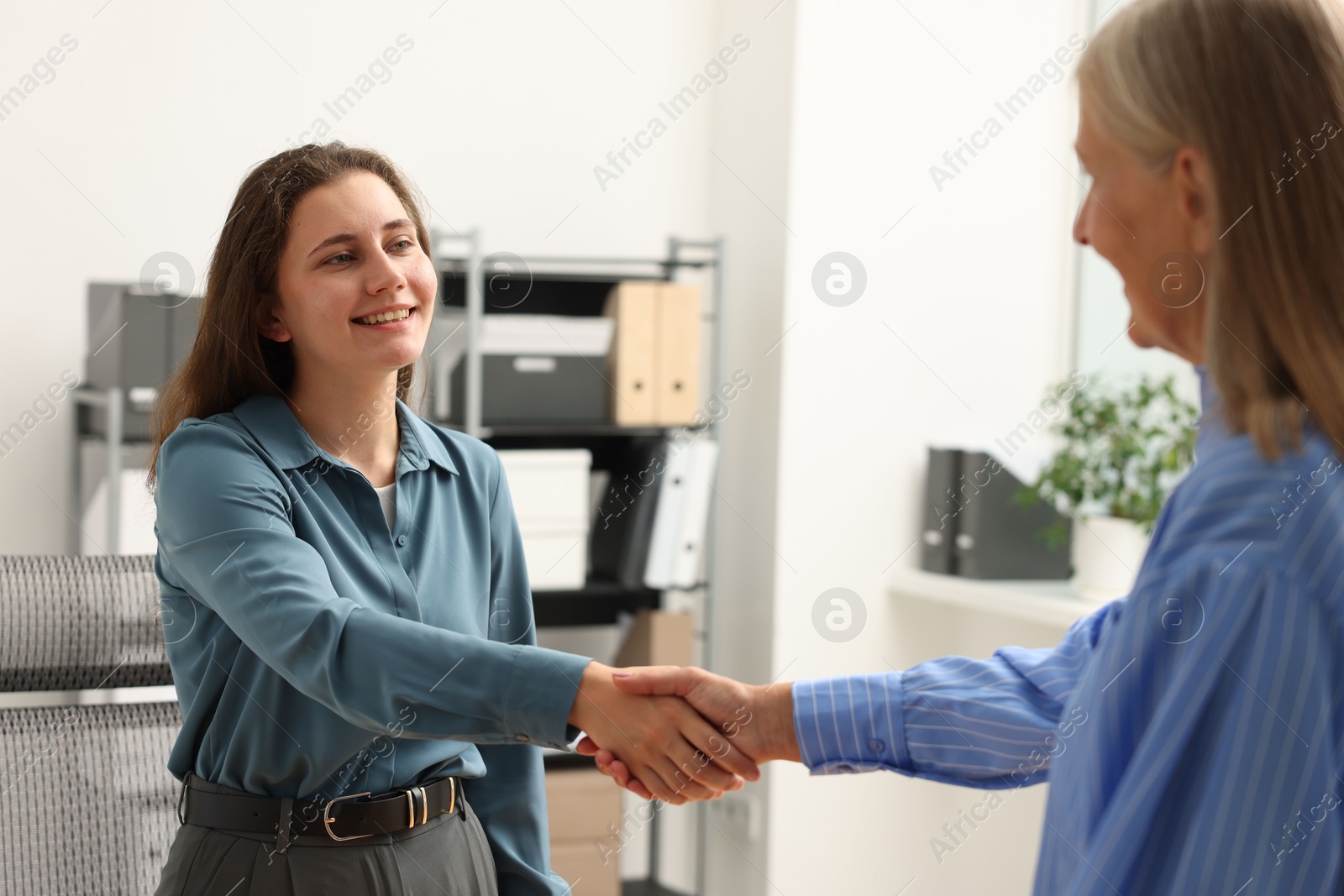 Photo of Cooperation and teamwork. Women shaking hands in office