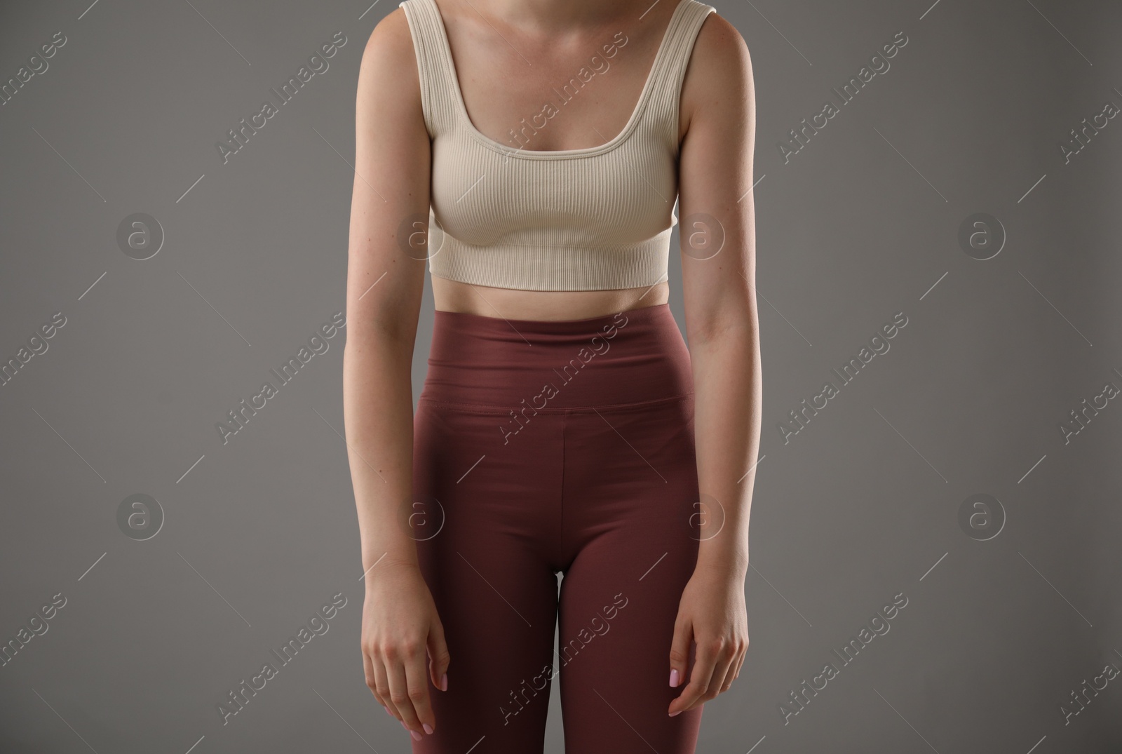 Woman with bad posture on grey background, closeup Photo of Woman with bad posture on grey background, closeup