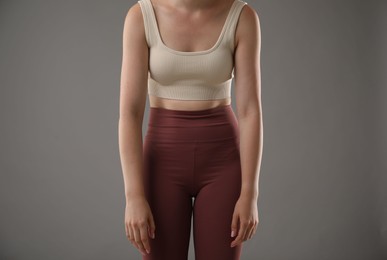Photo of Woman with bad posture on grey background, closeup