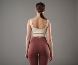 Photo of Woman with good posture on grey background, back view