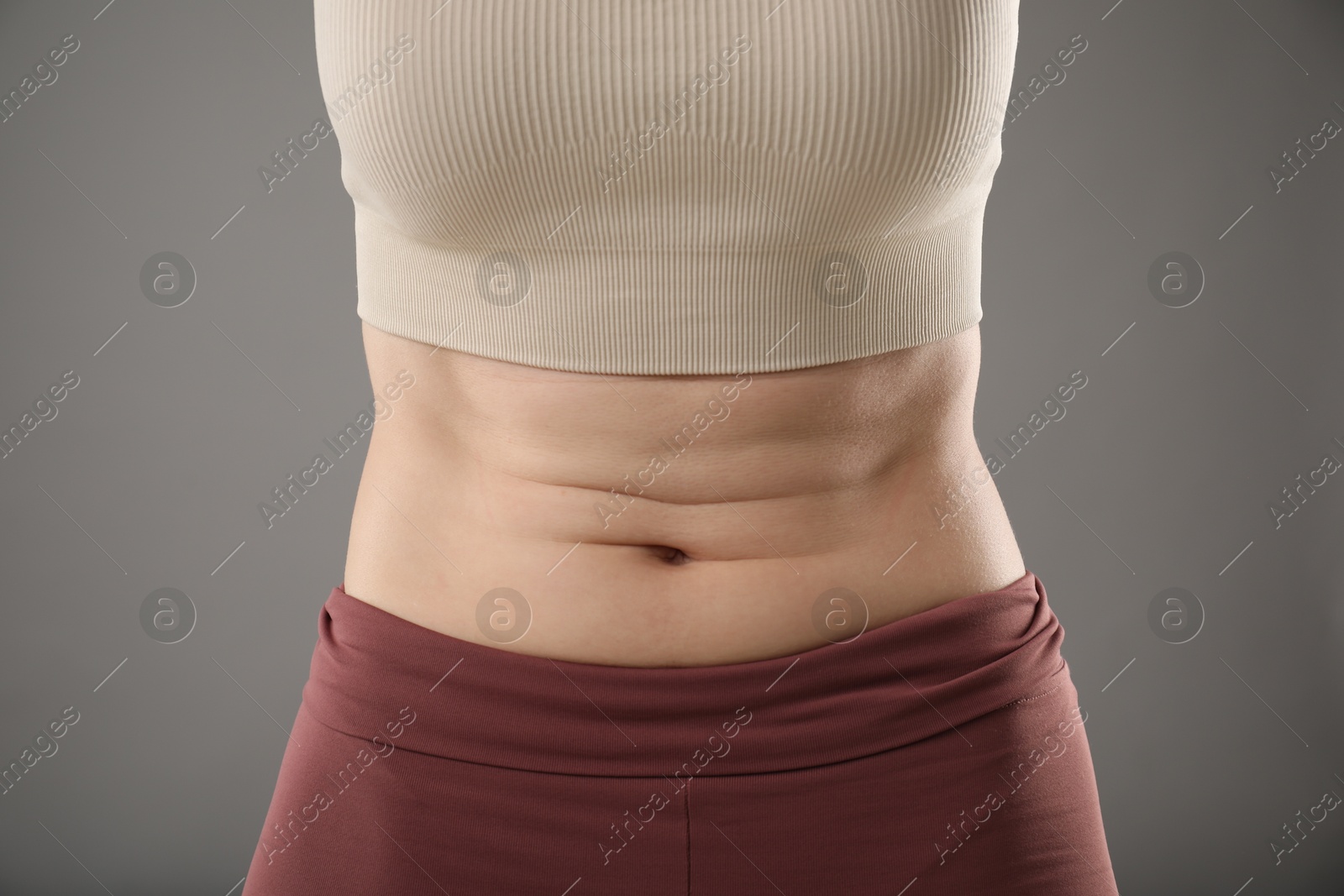 Photo of Woman after weight loss on grey background, closeup