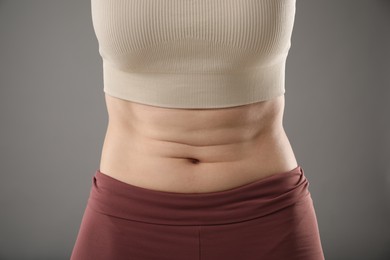 Photo of Woman after weight loss on grey background, closeup
