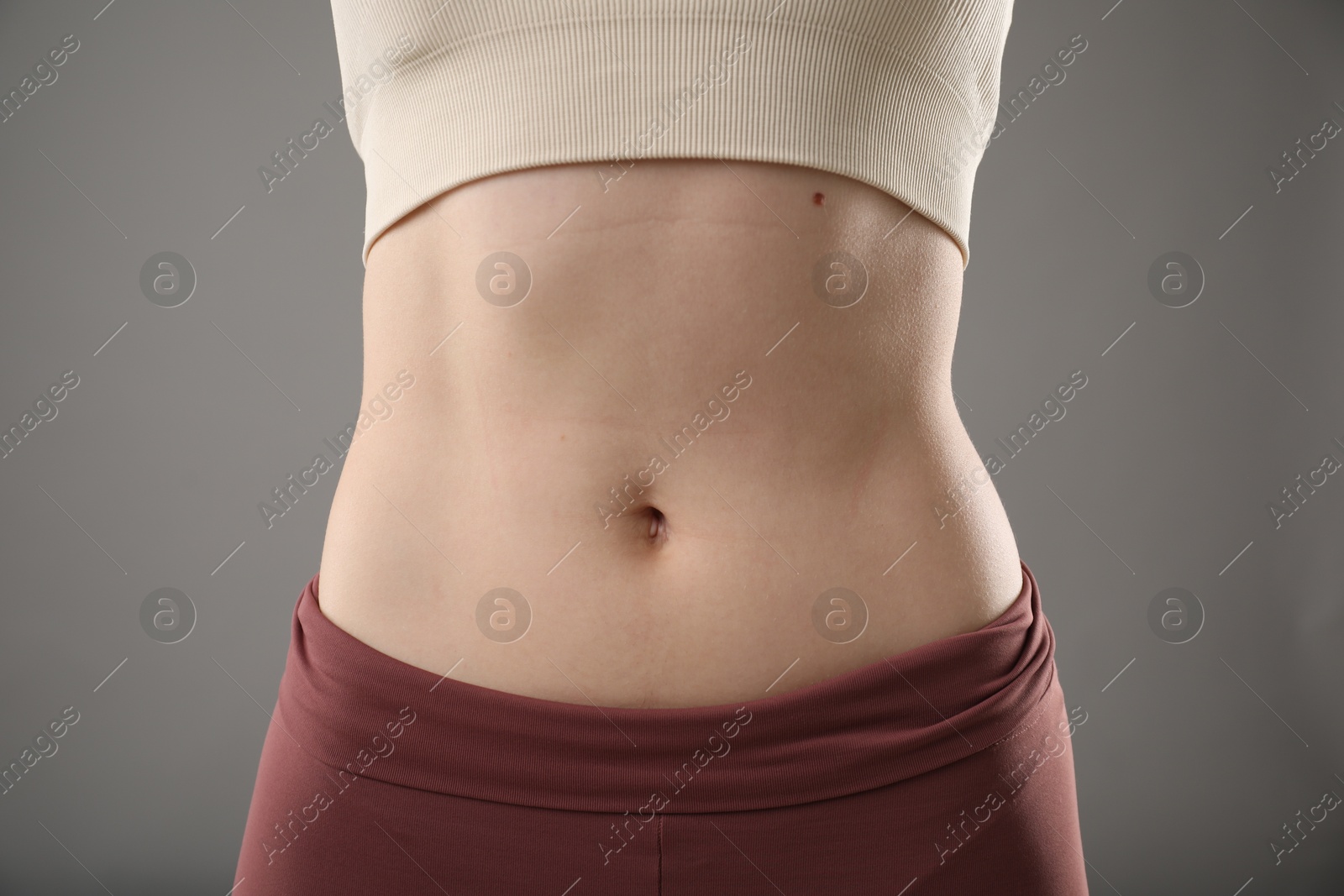 Photo of Woman after weight loss on grey background, closeup