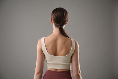 Photo of Woman with good posture on grey background, back view