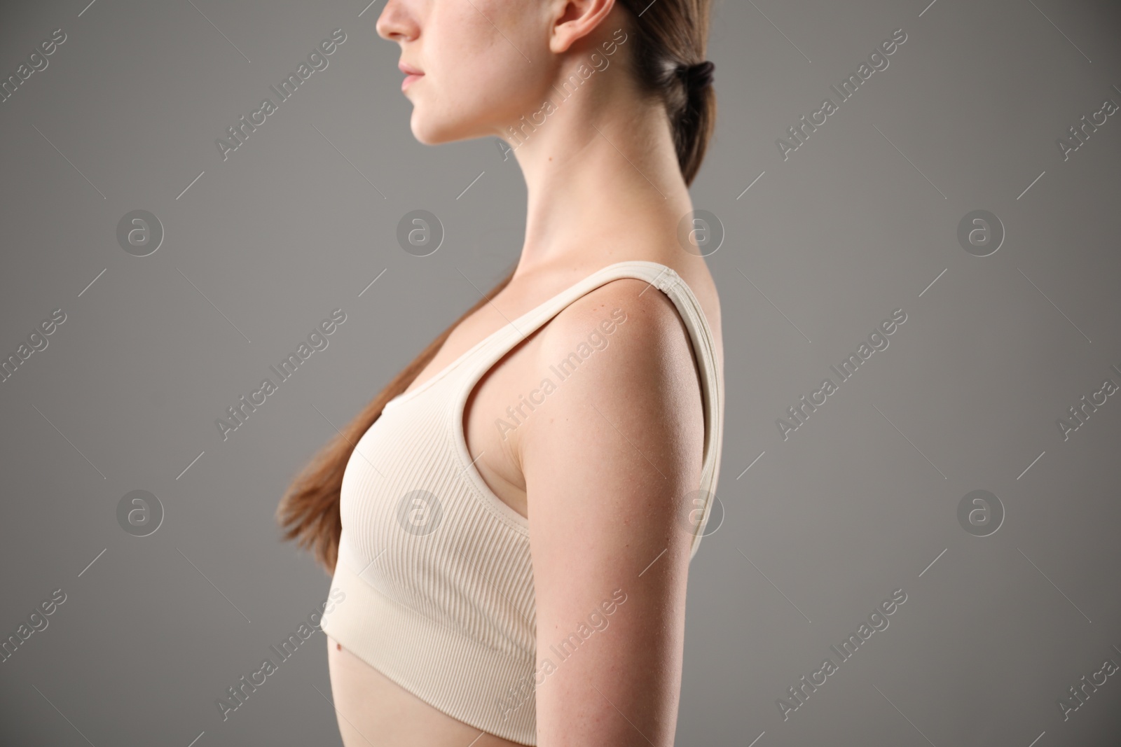 Woman with good posture on grey background, closeup Photo of Woman with good posture on grey background, closeup