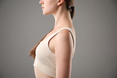 Photo of Woman with good posture on grey background, closeup