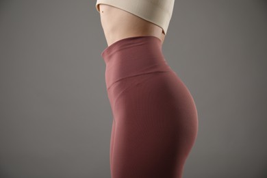 Photo of Woman in sportswear on grey background, closeup