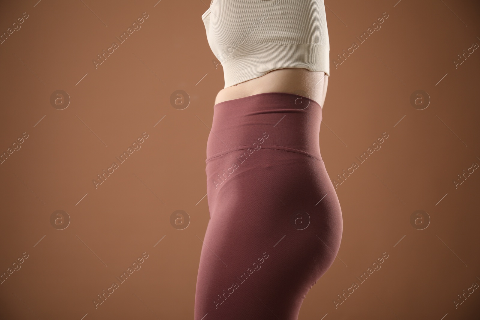 Woman with bad posture on brown background, closeup Photo of Woman with bad posture on brown background, closeup