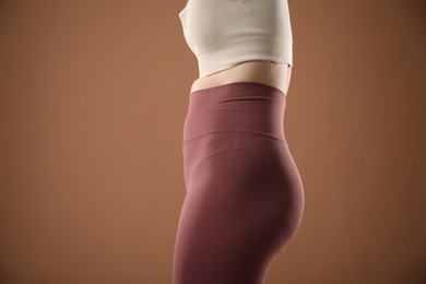Photo of Woman with bad posture on brown background, closeup