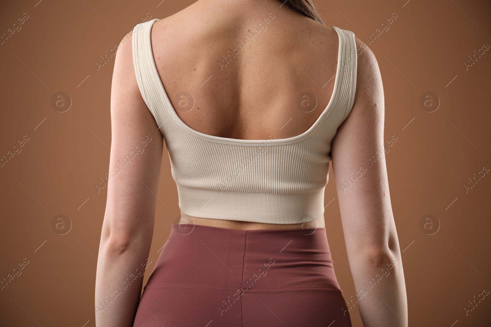 Woman with good posture on brown background, closeup Photo of Woman with good posture on brown background, closeup