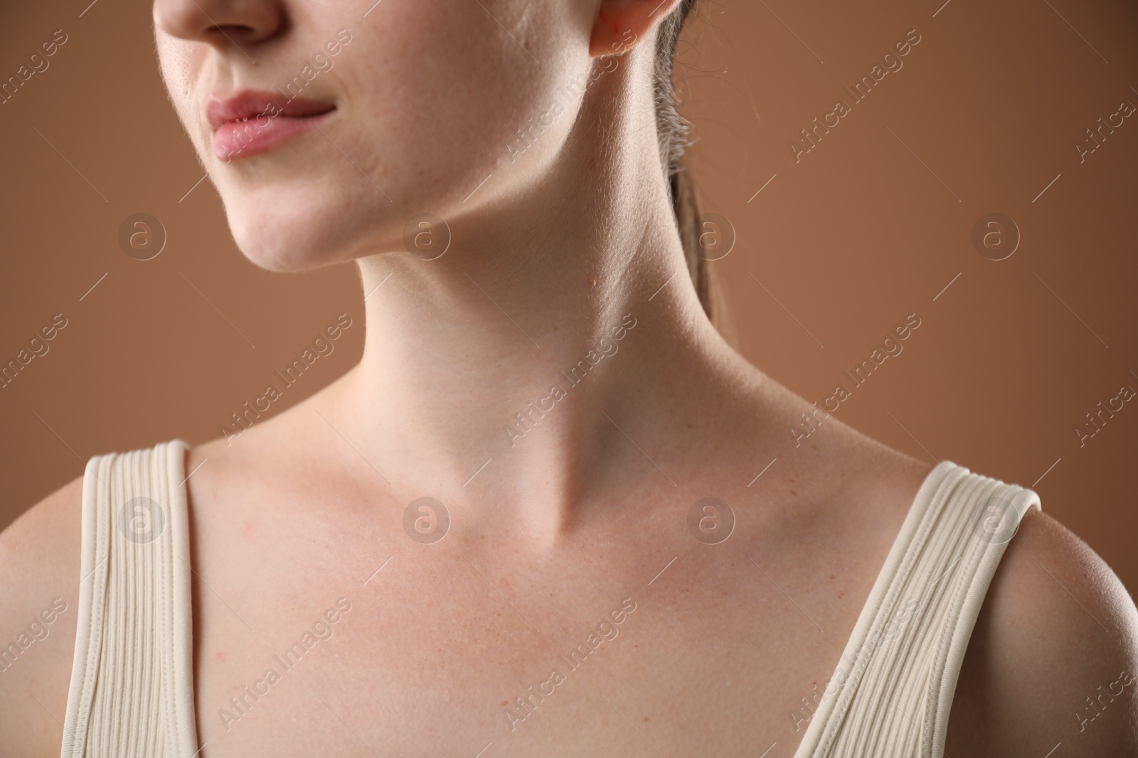 Closeup view of woman on brown background Photo of Closeup view of woman on brown background
