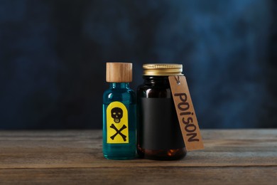 Photo of Bottles of poisons with warning sign on wooden table against dark background with smoke
