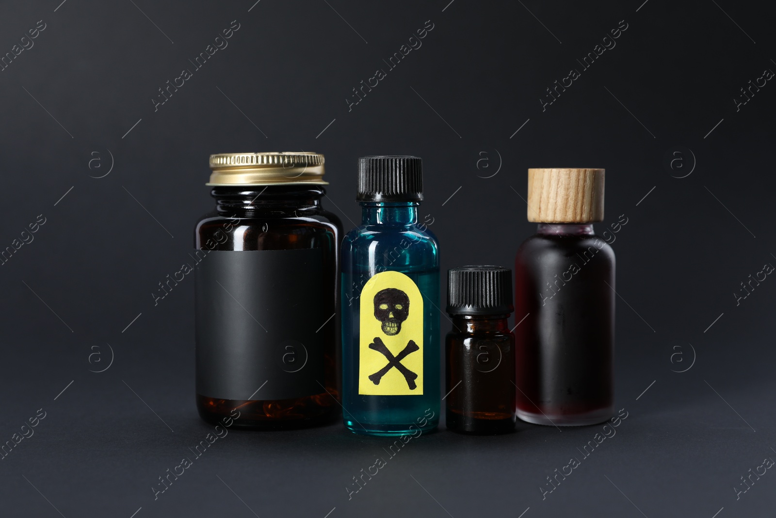 Bottles of poisons with warning sign on black background Photo of Bottles of poisons with warning sign on black background