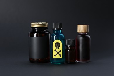 Photo of Bottles of poisons with warning sign on black background