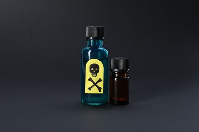 Photo of Bottles of poisons with warning sign on black background