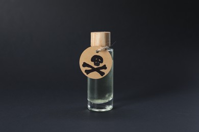Photo of One bottle of poison with warning sign on black background