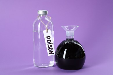 Photo of Glass bottles with poisons on violet background