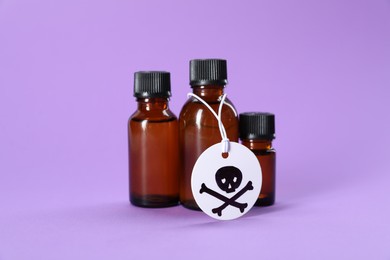Photo of Bottles of poisons with warning sign on violet background