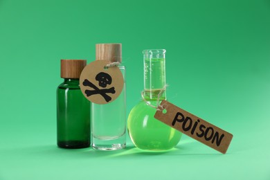 Photo of Bottles of poisons with warning sign on green background