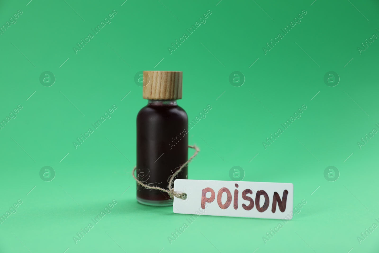 Bottle with poison on green background, closeup Photo of Bottle with poison on green background, closeup