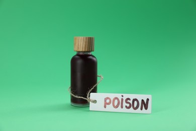 Photo of Bottle with poison on green background, closeup