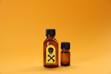 Photo of Bottles of poisons with warning sign on orange background