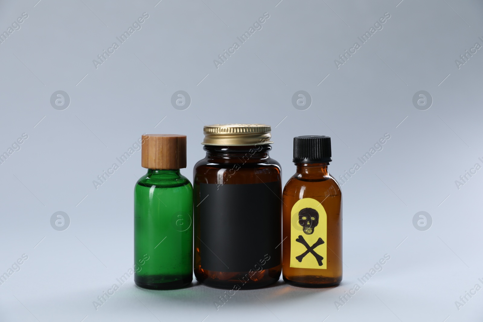 Photo of Bottles of poisons with warning sign on light grey background