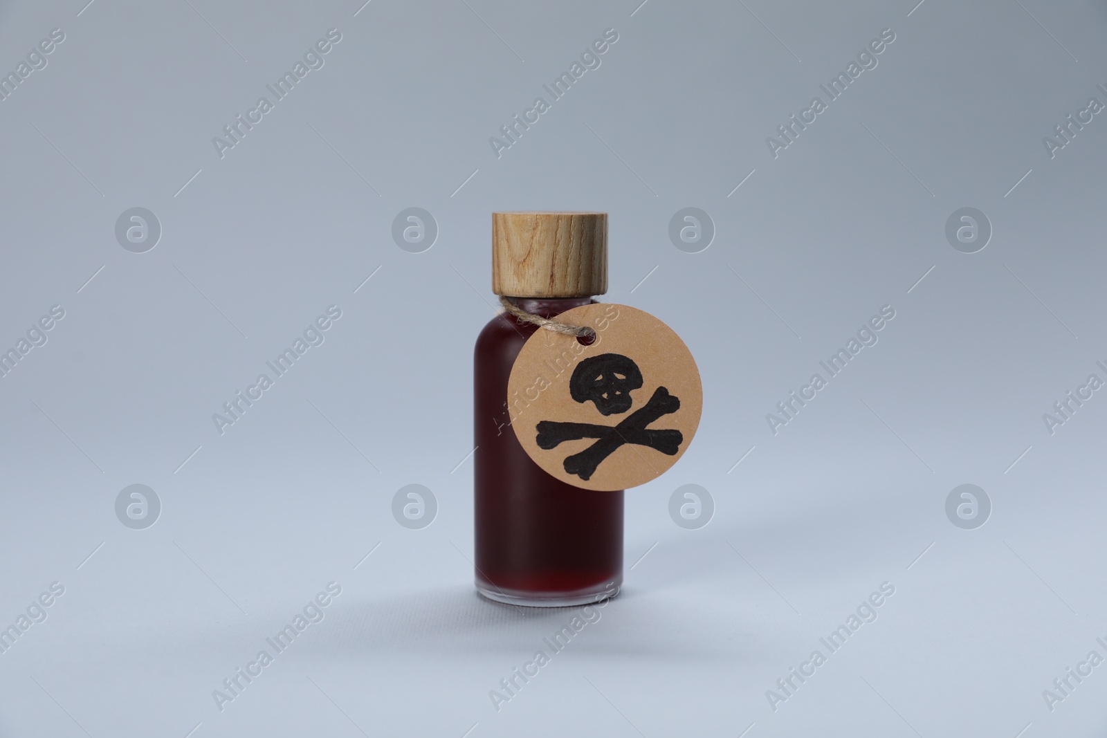 Bottle of poison with warning sign on light grey background Photo of Bottle of poison with warning sign on light grey background