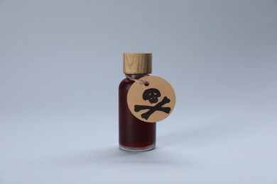 Photo of Bottle of poison with warning sign on light grey background