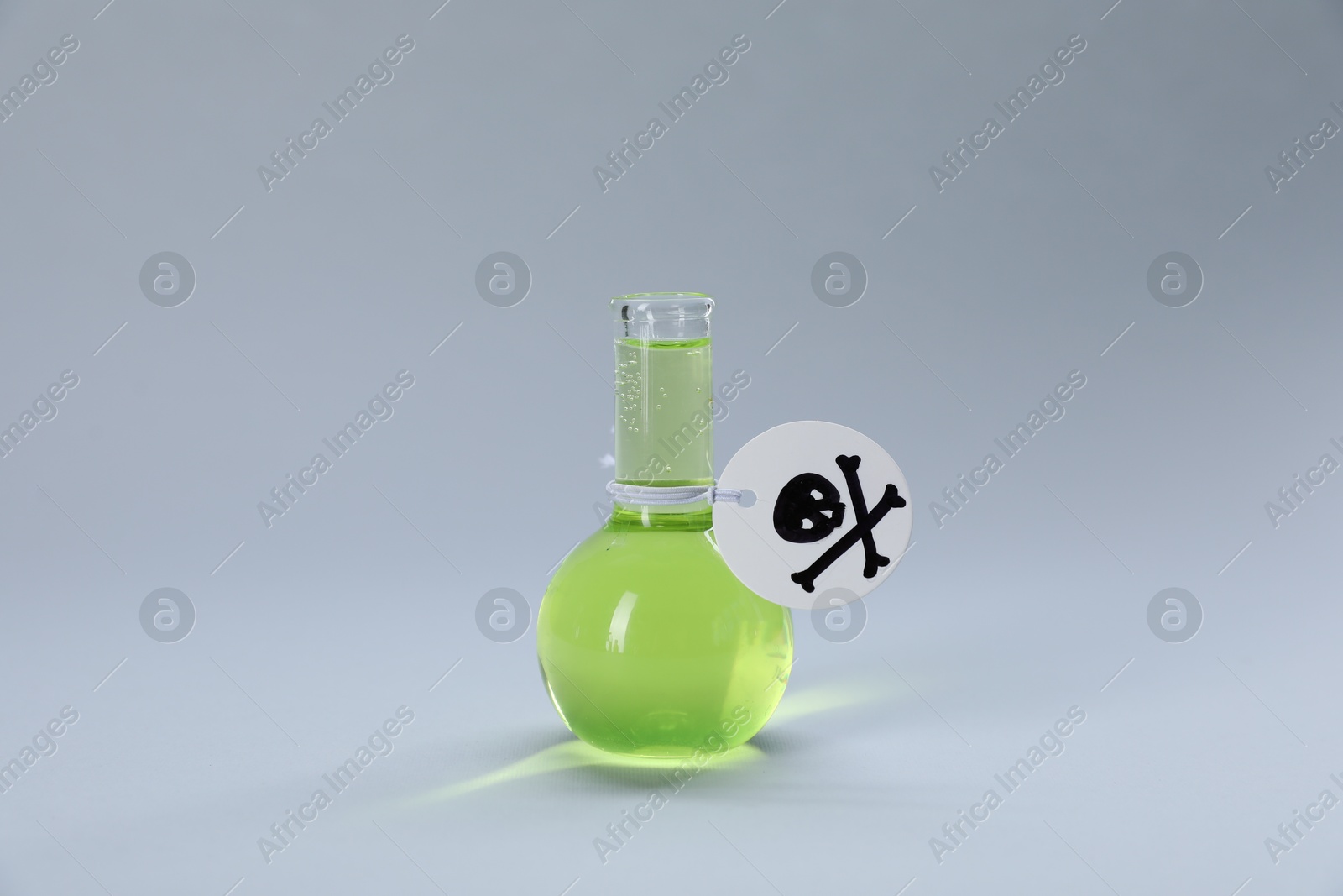 Flask of poison with warning sign on light grey background Photo of Flask of poison with warning sign on light grey background