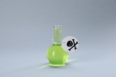 Photo of Flask of poison with warning sign on light grey background