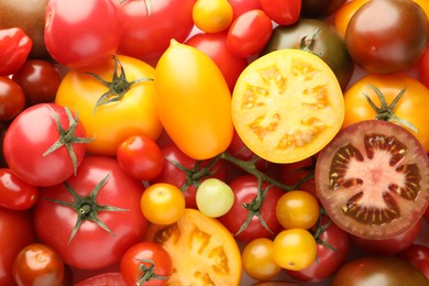 Photo of Different ripe juicy tomatoes as background, closeup