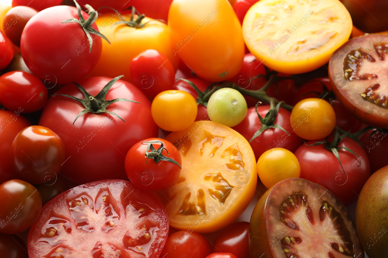 Photo of Different ripe juicy tomatoes as background, closeup