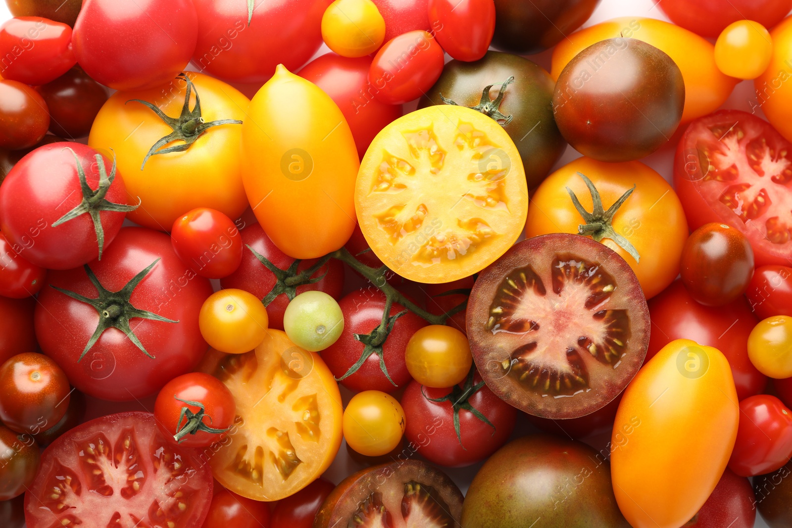 Photo of Different ripe juicy tomatoes as background, closeup
