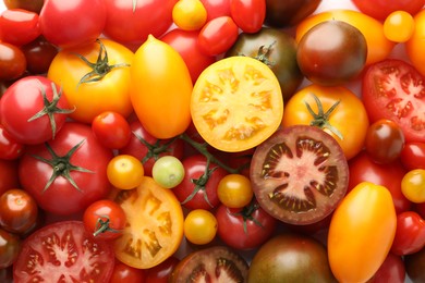 Photo of Different ripe juicy tomatoes as background, closeup