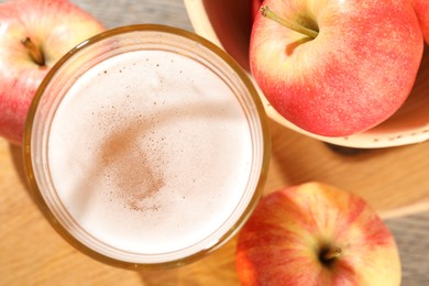 Photo of Delicious cider in glass and apples on grey wooden table, flat lay