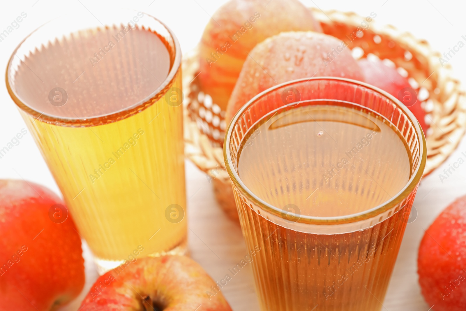 Delicious cider in glasses and red apples on white wooden table, closeup Photo of Delicious cider in glasses and red apples on white wooden table, closeup