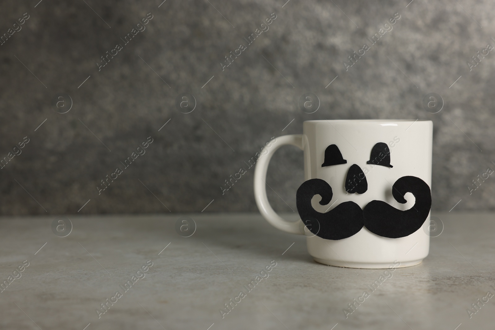 Happy Father's Day. Cup with paper face on light grey table, space for text Photo of Happy Father's Day. Cup with paper face on light grey table, space for text