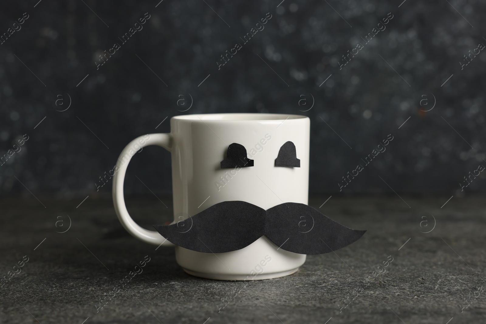 Happy Father's Day. Cup with paper face on black table Photo of Happy Father's Day. Cup with paper face on black table