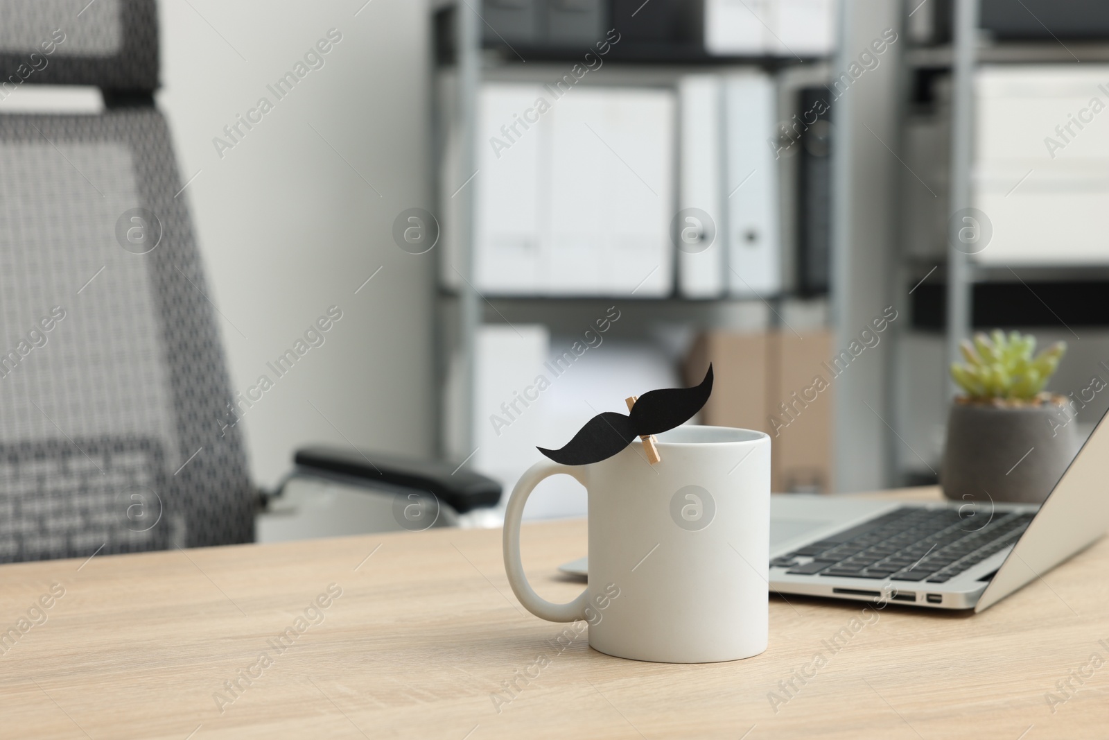 Happy Father's Day. Cup with paper moustache and laptop on wooden table, space for text Photo of Happy Father's Day. Cup with paper moustache and laptop on wooden table, space for text