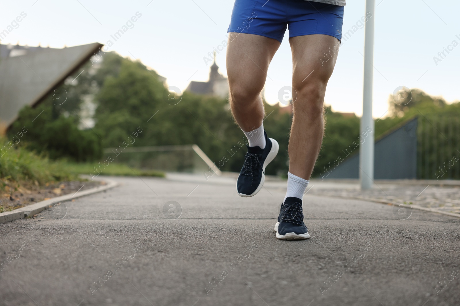 Athletic young man in sportswear running outdoors, closeup. Space for text Photo of Athletic young man in sportswear running outdoors, closeup. Space for text