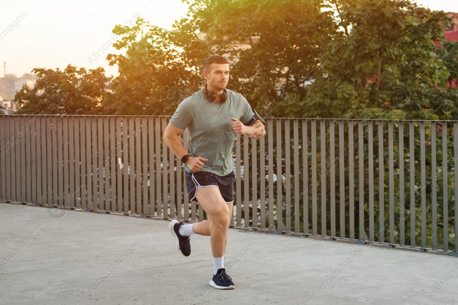 Athletic young man in sportswear running outdoors Photo of Athletic young man in sportswear running outdoors