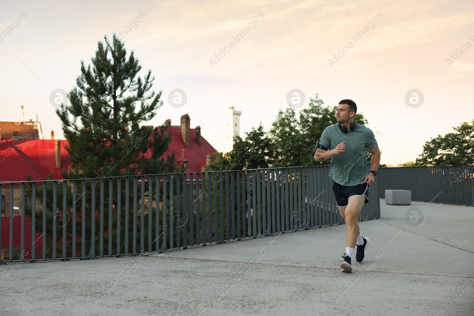 Athletic young man in sportswear running outdoors, space for text Photo of Athletic young man in sportswear running outdoors, space for text
