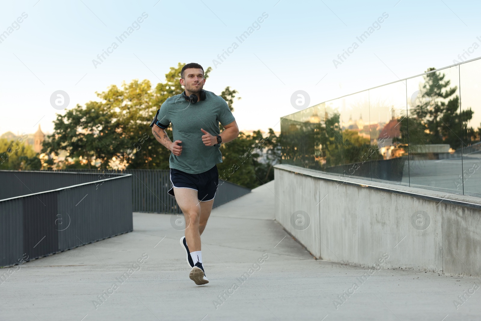 Athletic young man in sportswear running outdoors Photo of Athletic young man in sportswear running outdoors
