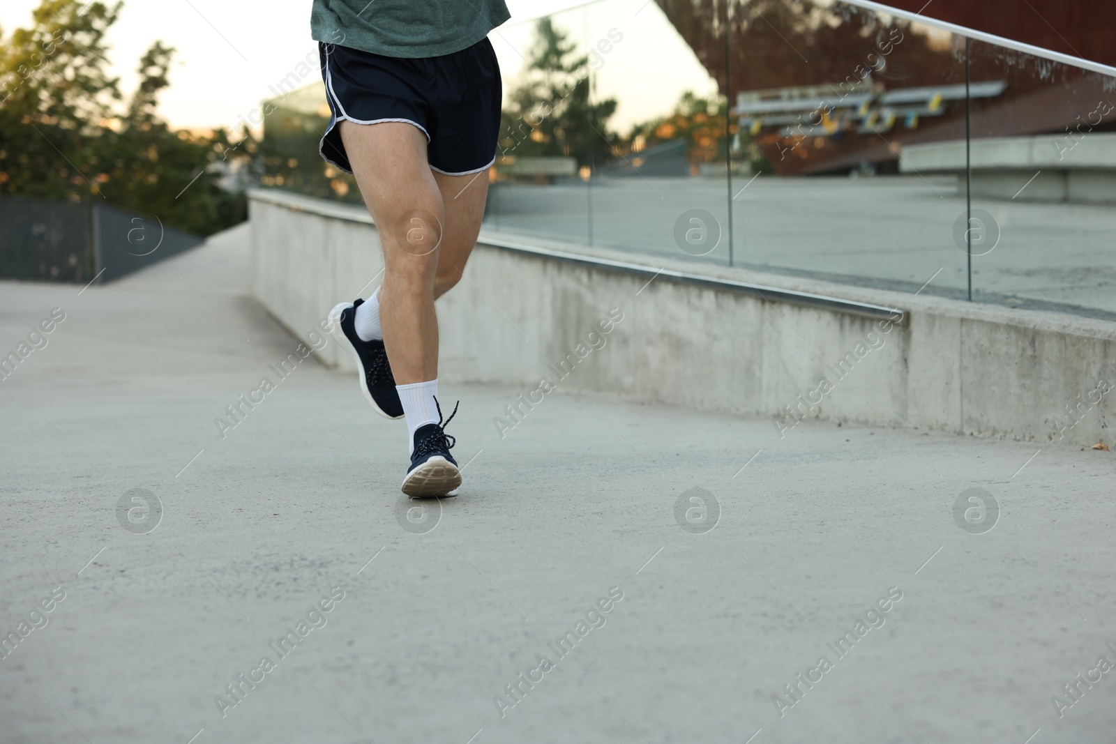 Athletic young man in sportswear running outdoors, closeup. Space for text Photo of Athletic young man in sportswear running outdoors, closeup. Space for text