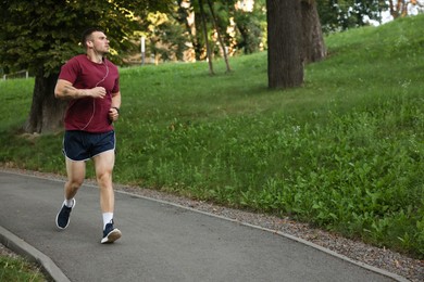 Photo of Athletic young man in sportswear running outdoors
