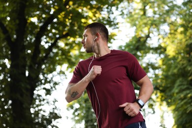 Photo of Athletic young man in sportswear running outdoors