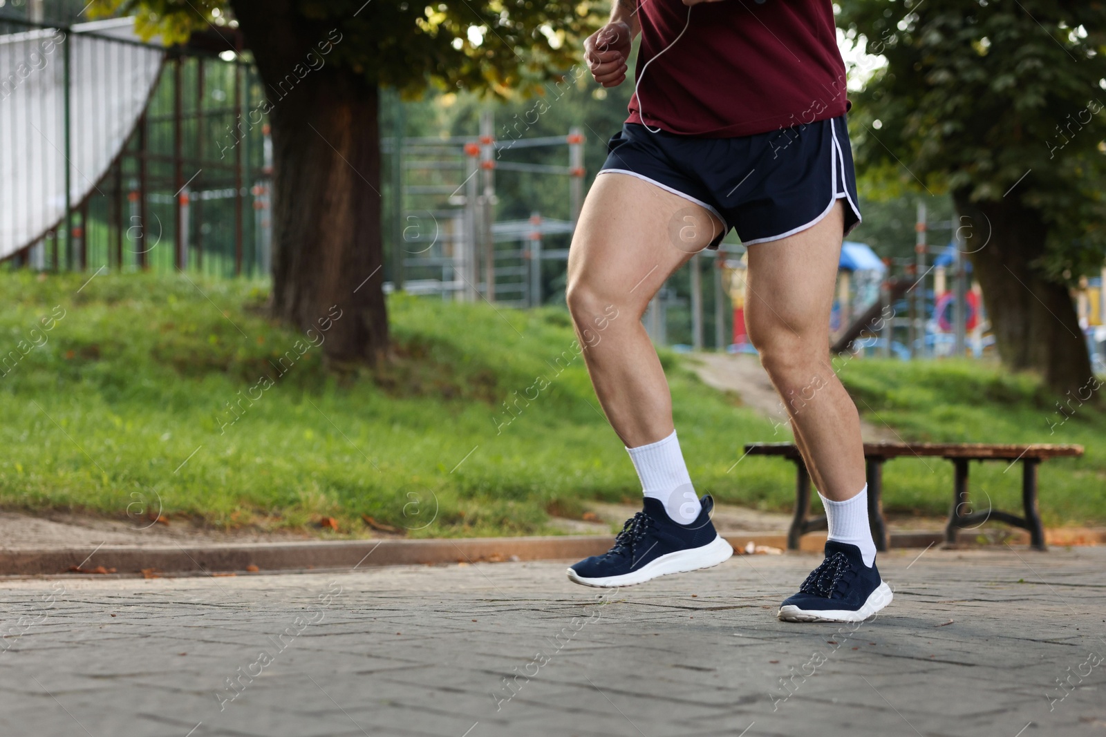 Athletic young man in sportswear running outdoors, closeup. Space for text Photo of Athletic young man in sportswear running outdoors, closeup. Space for text