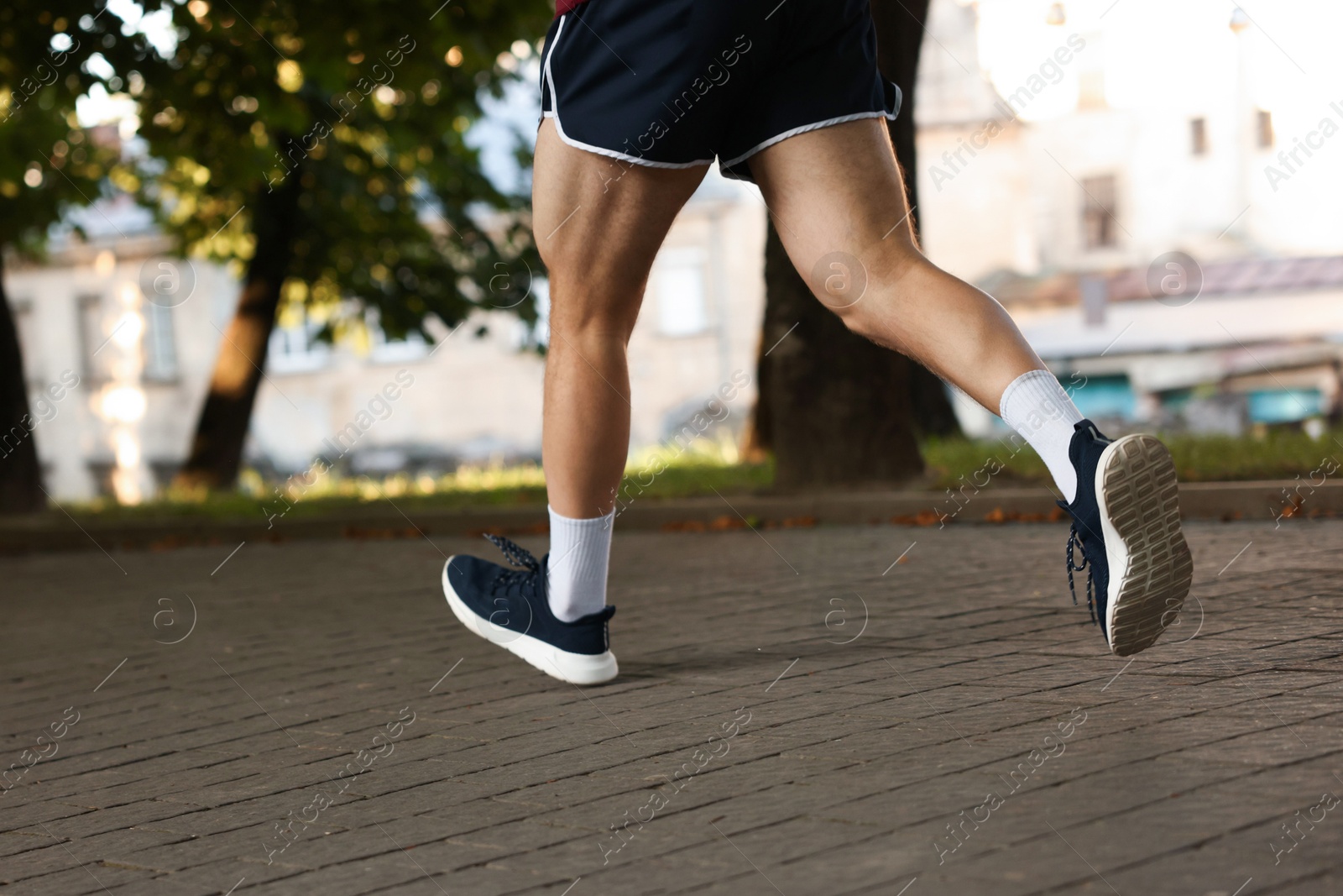 Athletic young man in sportswear running outdoors, closeup Photo of Athletic young man in sportswear running outdoors, closeup
